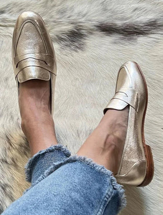 Shiny light gold metallic slip-on loafers for women with a clean silhouette
