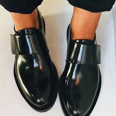 Black polished strap loafers with glossy finish and clean strap detail