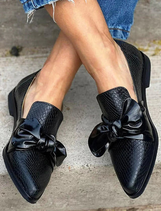 Black loafer with textured finish and a bold shiny bow detail