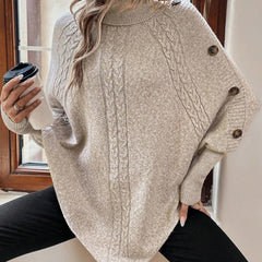High neck batwing poncho sweater in cable knit with asymmetrical hem and button shoulder detail
