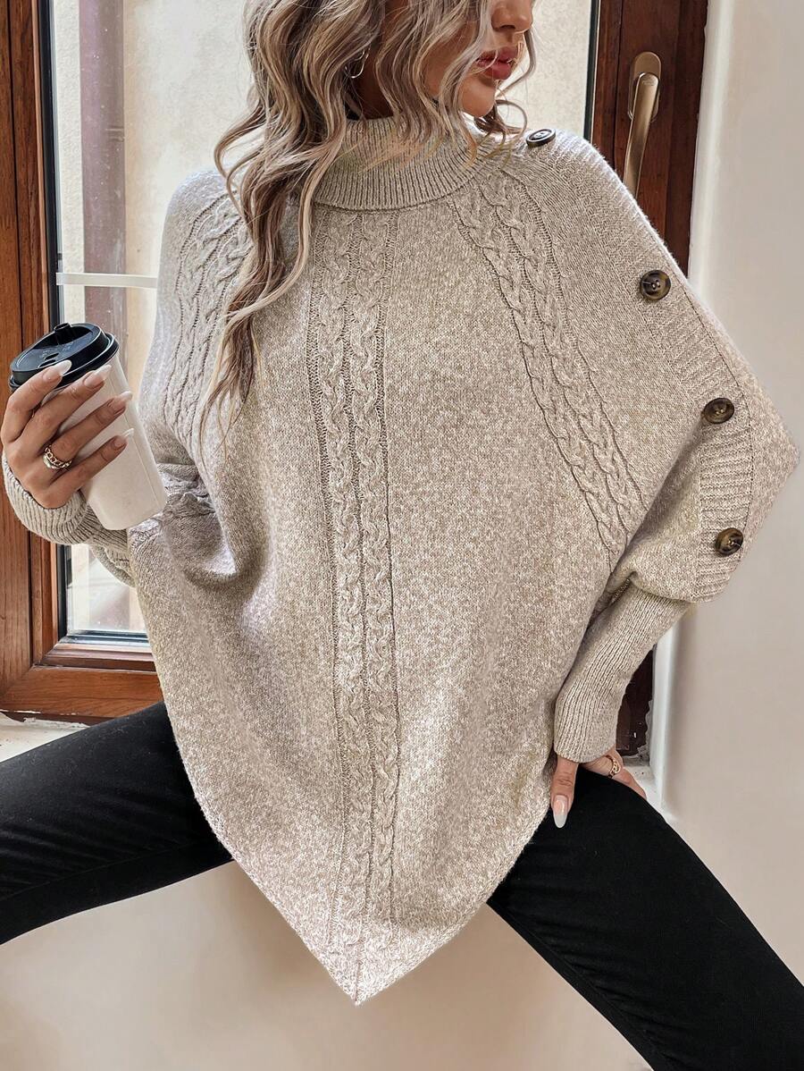 High neck batwing poncho sweater in cable knit with asymmetrical hem and button shoulder detail