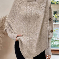 High neck batwing poncho sweater in cable knit with asymmetrical hem and button shoulder detail