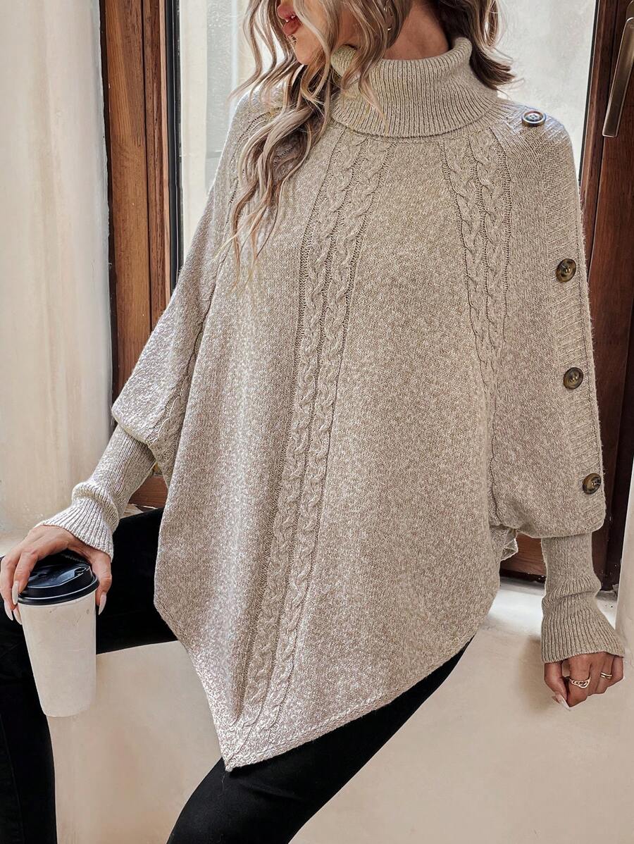 High neck batwing poncho sweater in cable knit with asymmetrical hem and button shoulder detail