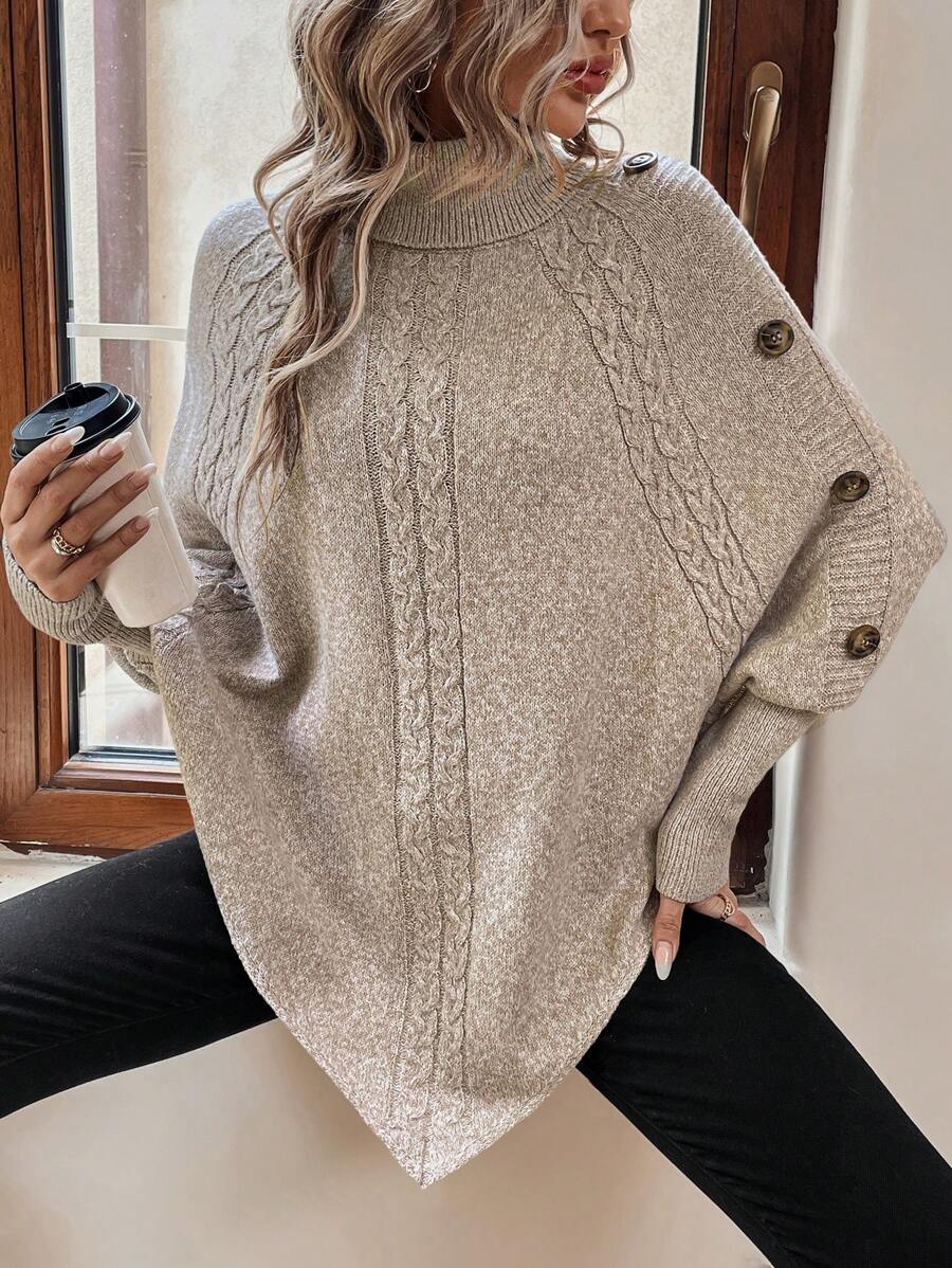 High neck batwing poncho sweater in cable knit with asymmetrical hem and button shoulder detail