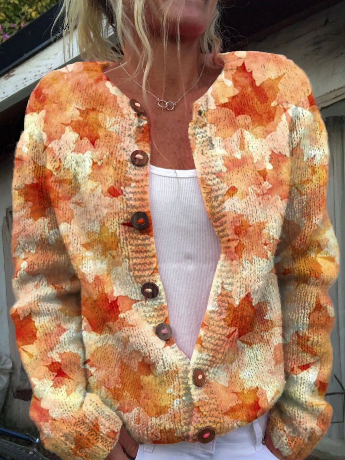 Women's open-front knit cardigan with orange, red and cream maple leaf print and tortoise buttons