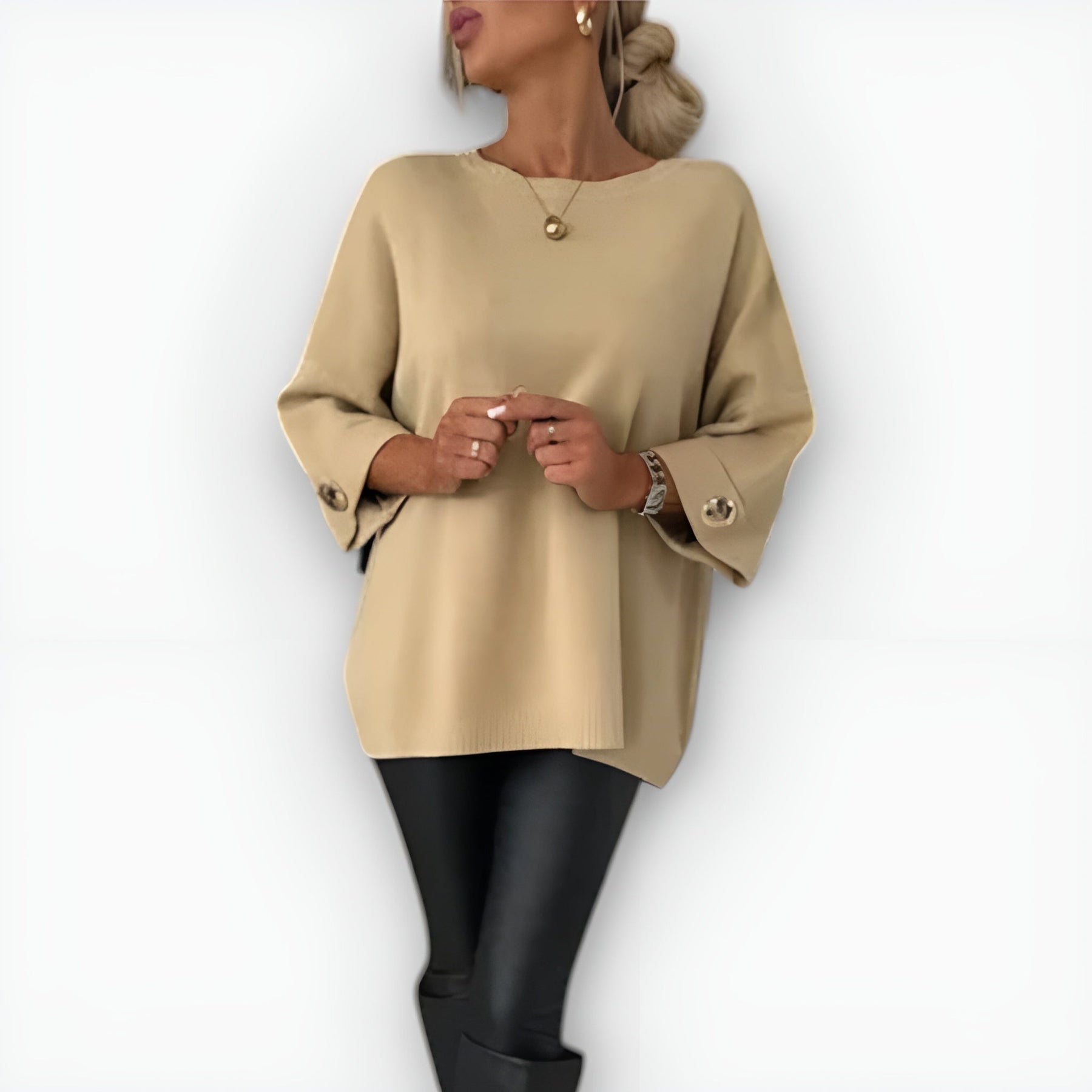 Oversized women's sweater with round neckline, three-quarter sleeves and button-detailed cuffs