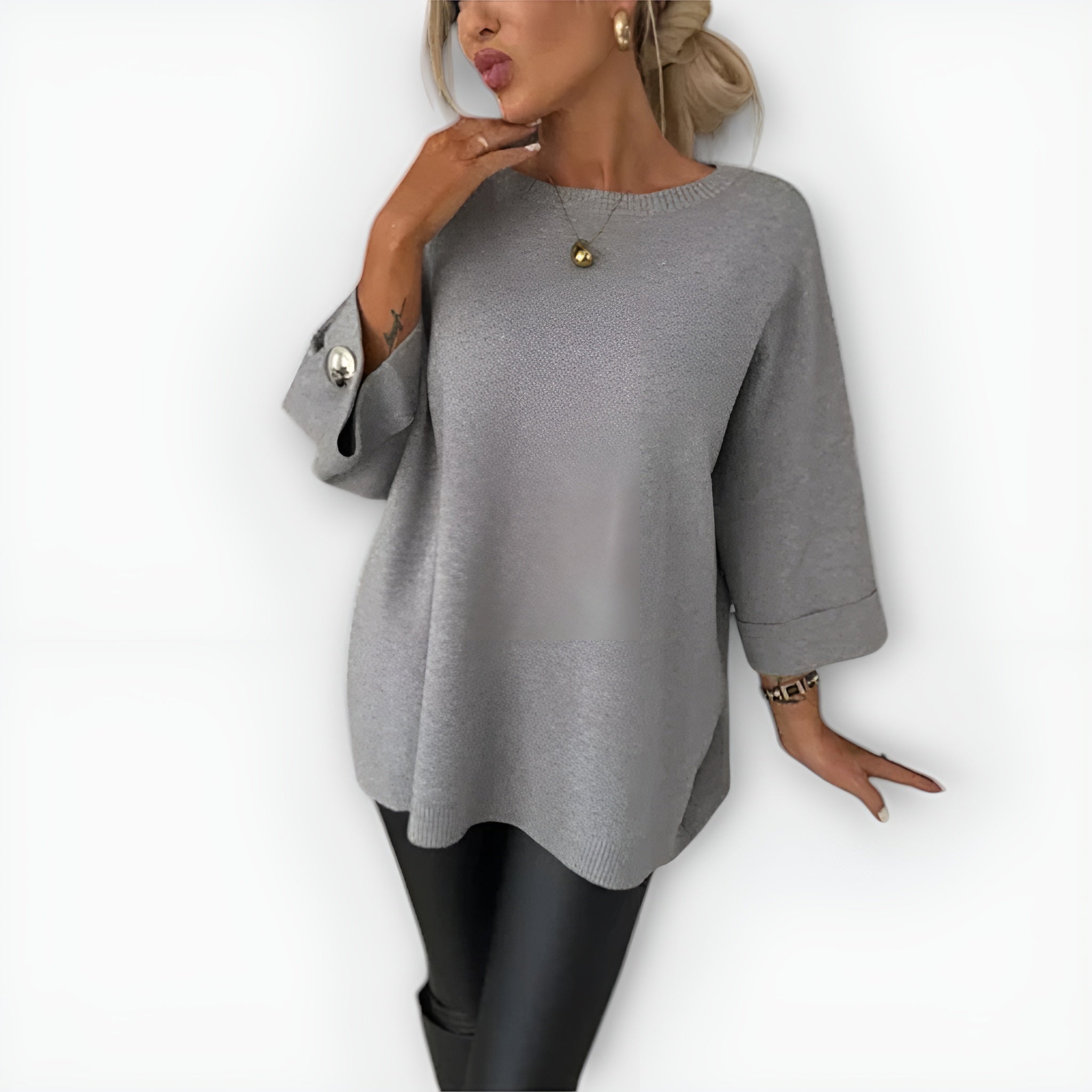 Oversized women's sweater with round neckline, three-quarter sleeves and button-detailed cuffs