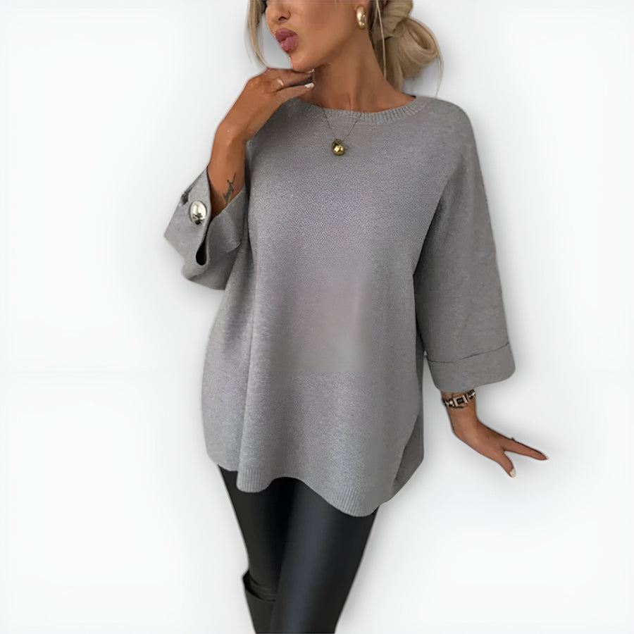 Oversized women's sweater with round neckline, three-quarter sleeves and button-detailed cuffs