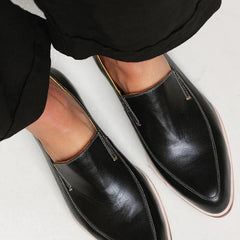 Black minimalist loafers with clean lines and a modern silhouette