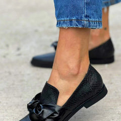 Black loafer with textured finish and a bold shiny bow detail