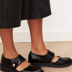 Black buckle loafers with polished finish and bold strap detail