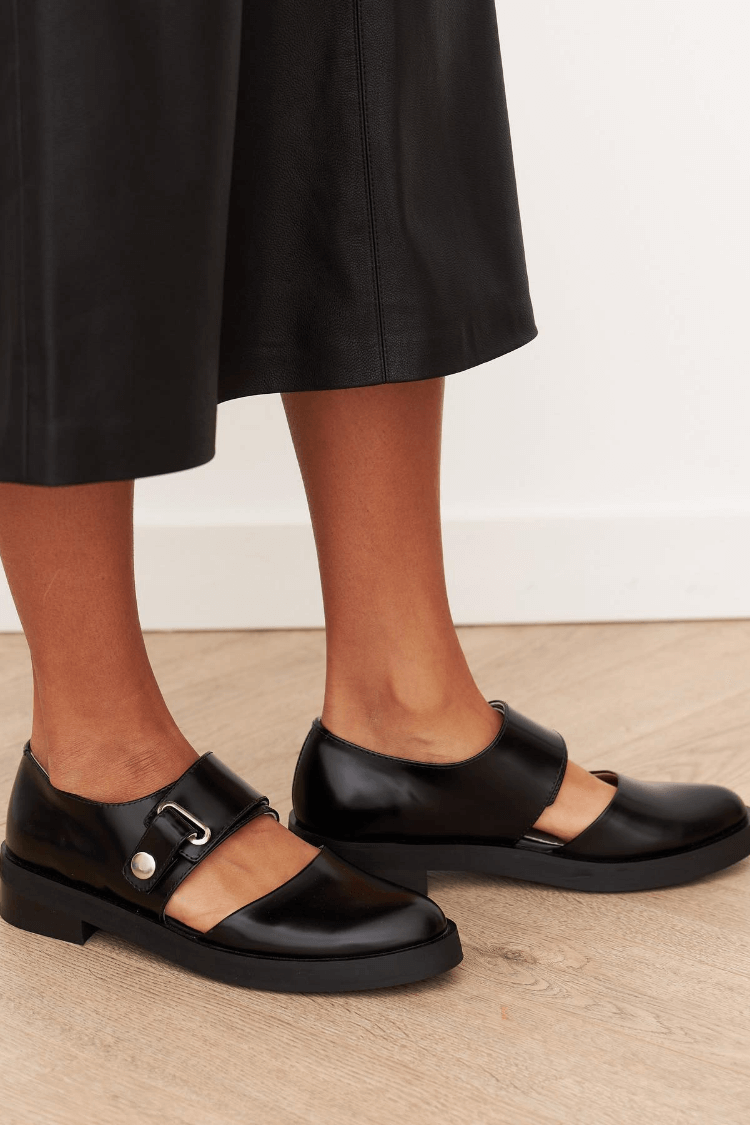 Black buckle loafers with polished finish and bold strap detail