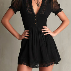 Black smocked mini dress with delicate lace trim at neckline and hem