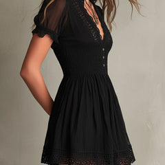 Black smocked mini dress with delicate lace trim at neckline and hem