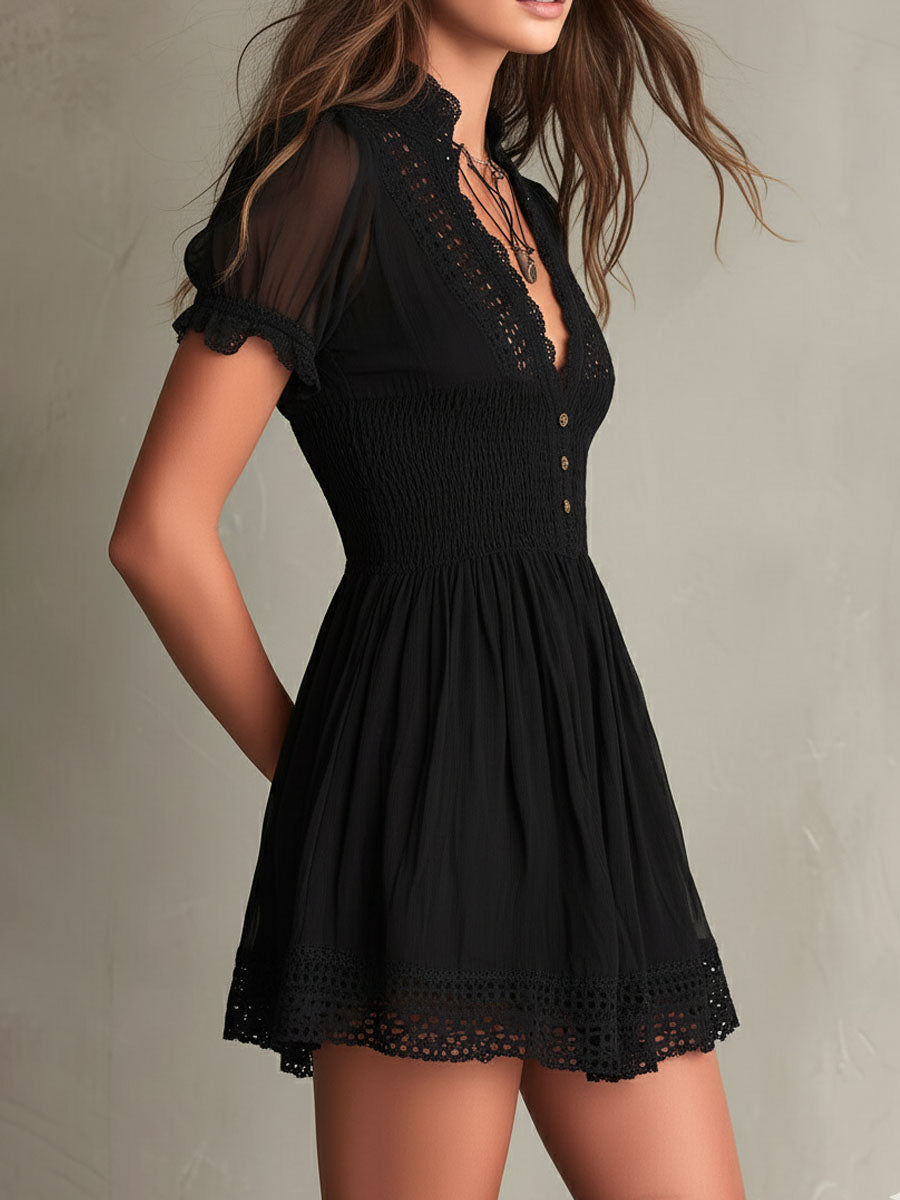 Black smocked mini dress with delicate lace trim at neckline and hem