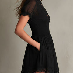 Black smocked mini dress with delicate lace trim at neckline and hem