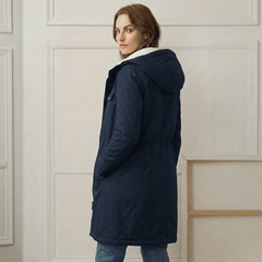 Woman wearing a cozy hooded longline weatherproof coat with plush lining and front pockets