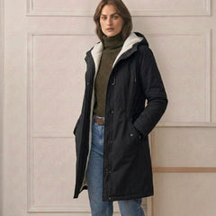 Woman wearing a cozy hooded longline weatherproof coat with plush lining and front pockets