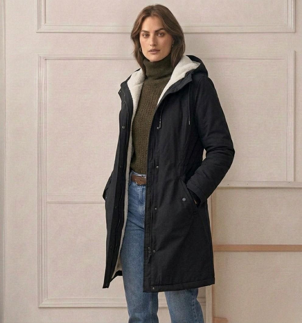 Woman wearing a cozy hooded longline weatherproof coat with plush lining and front pockets