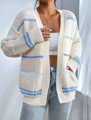 Woman wearing an oversized open-front knit cardigan with long sleeves in a soft tone