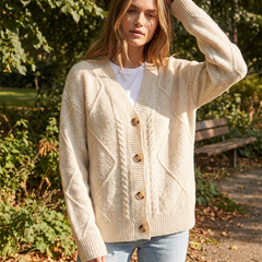 Cable knit button-front cardigan with long sleeves in soft neutral tones