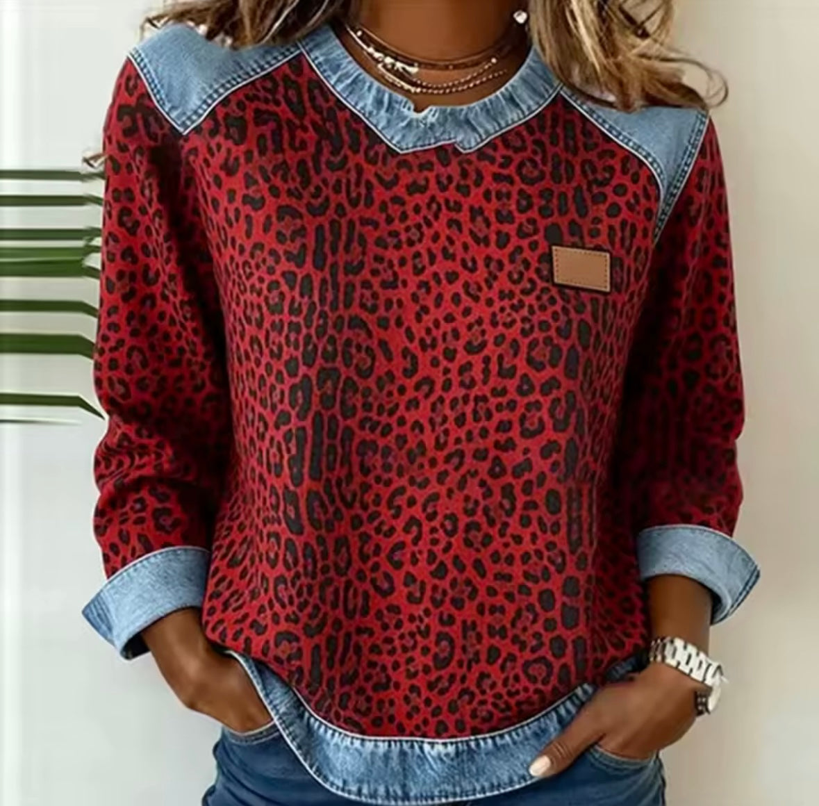 Leopard print sweater with contrast denim collar, cuffs, and hem in grey and red