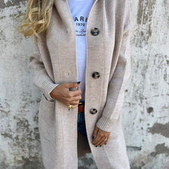 Woman wearing a long ribbed knit cardigan with large buttons and front pockets