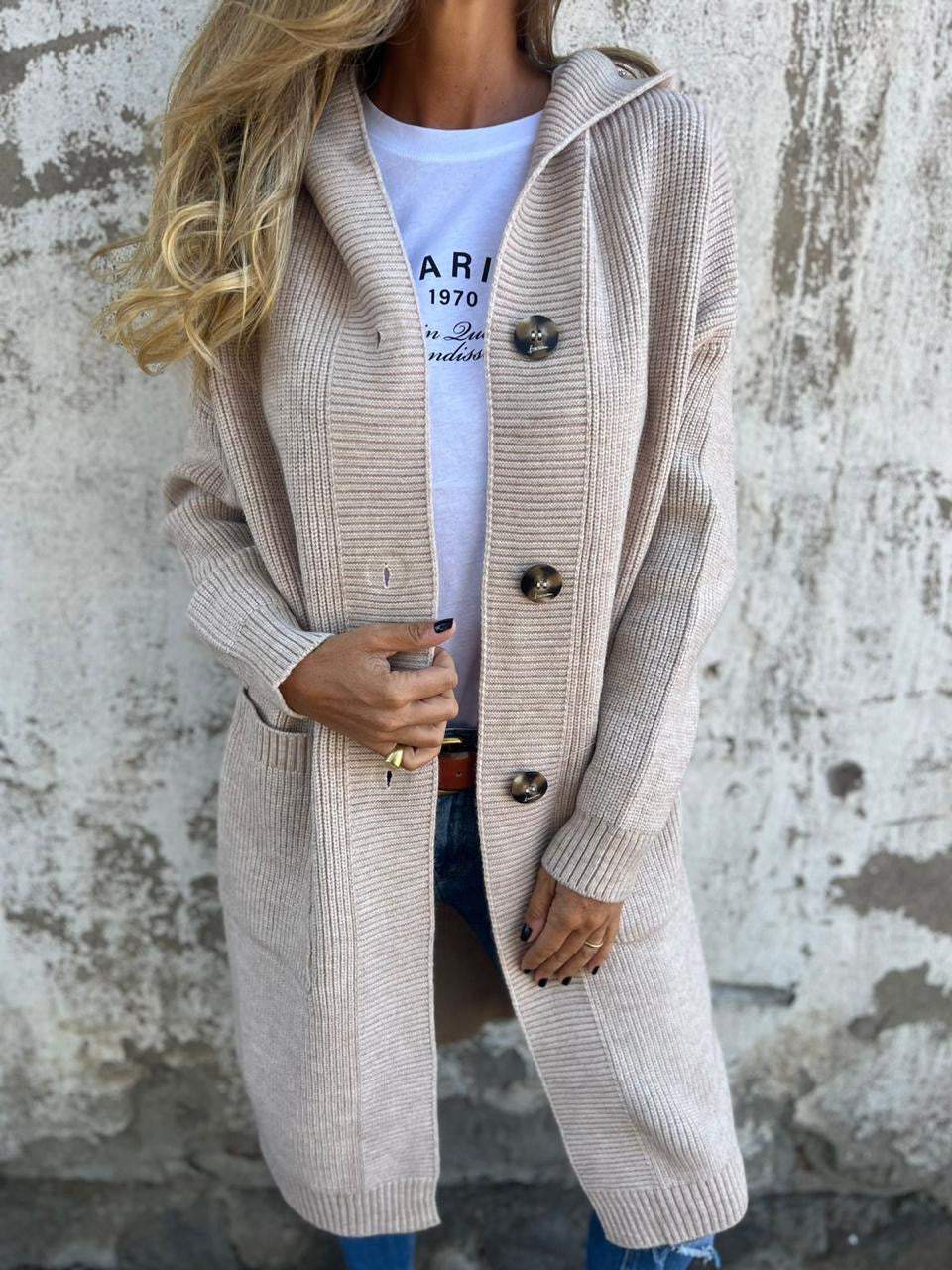 Woman wearing a long ribbed knit cardigan with large buttons and front pockets