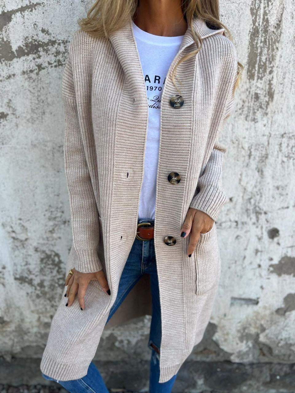 Woman wearing a long ribbed knit cardigan with large buttons and front pockets