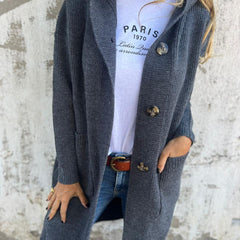 Woman wearing a long ribbed knit cardigan with large buttons and front pockets