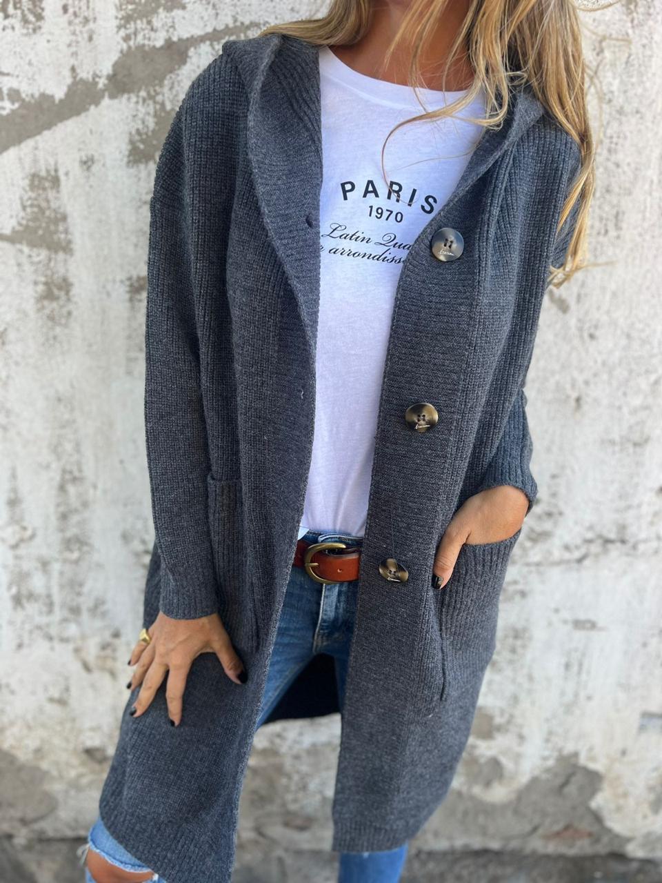 Woman wearing a long ribbed knit cardigan with large buttons and front pockets