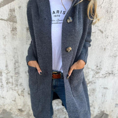 Woman wearing a long ribbed knit cardigan with large buttons and front pockets