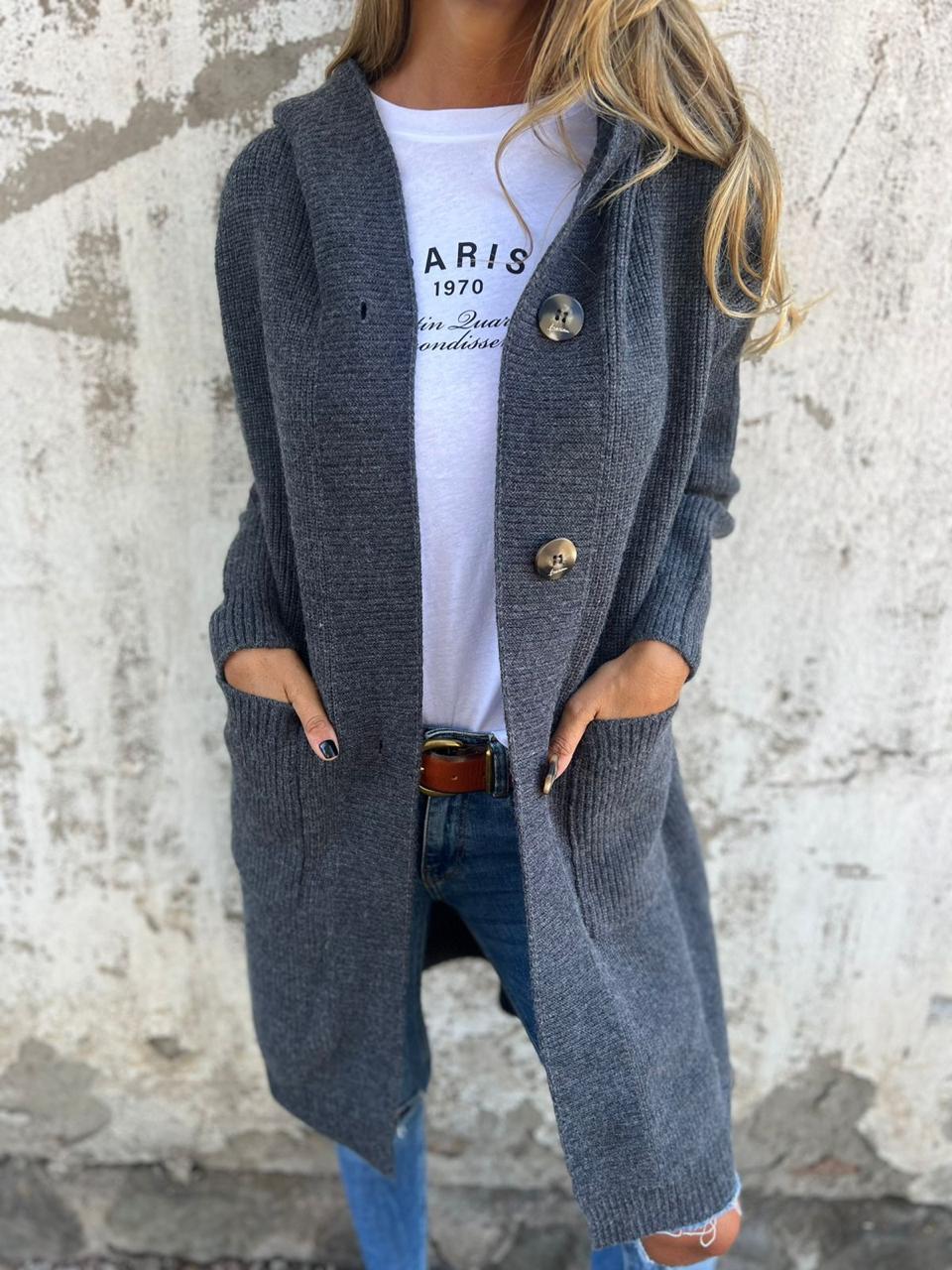 Woman wearing a long ribbed knit cardigan with large buttons and front pockets