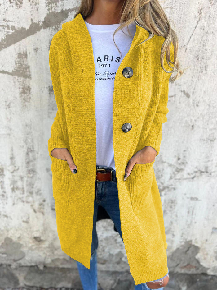 Woman wearing a long ribbed knit cardigan with large buttons and front pockets