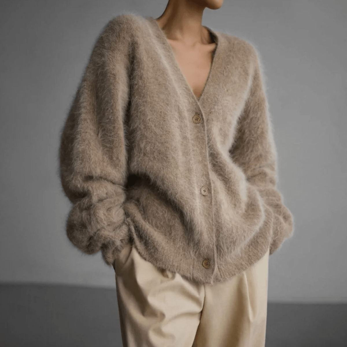 Fluffy knit cardigan with deep V-neck and oversized sleeves in neutral tones