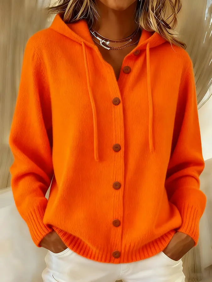 Woman wearing a soft button-front cardigan hoodie with drawstring hood and ribbed cuffs