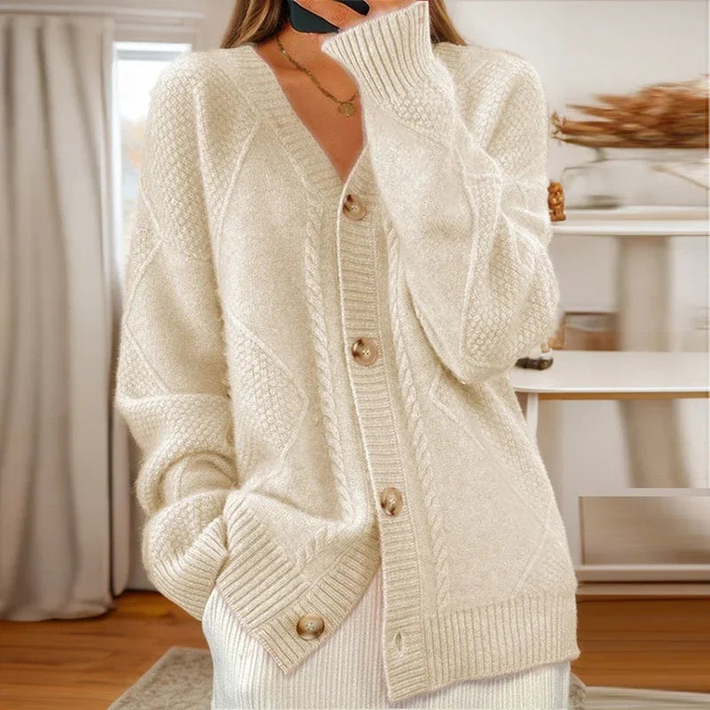 Cable knit button-front cardigan with long sleeves in soft neutral tones