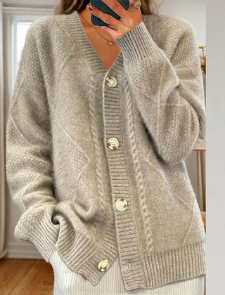 Cable knit button-front cardigan with long sleeves in soft neutral tones