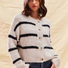 White striped button-down knit cardigan with long sleeves shown on a woman