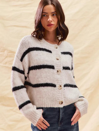 White striped button-down knit cardigan with long sleeves shown on a woman