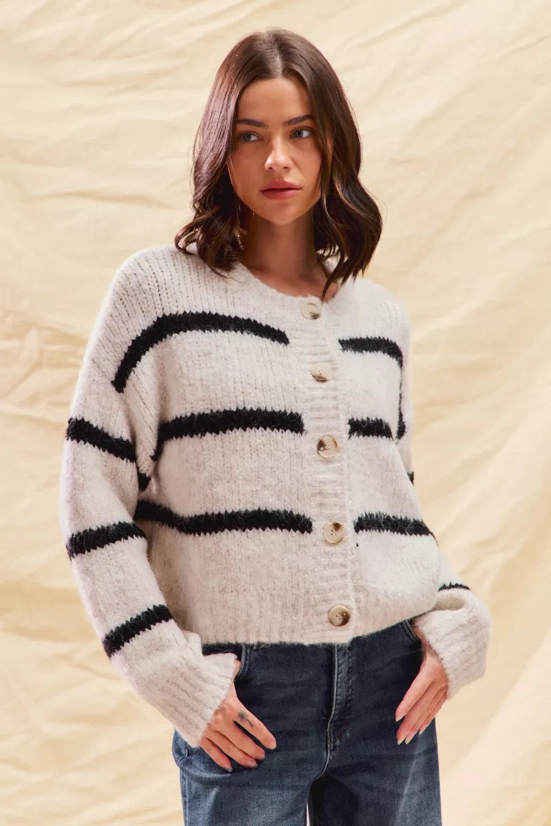 White striped button-down knit cardigan with long sleeves shown on a woman