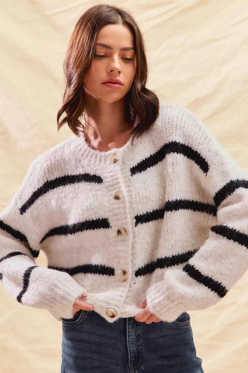 White striped button-down knit cardigan with long sleeves shown on a woman
