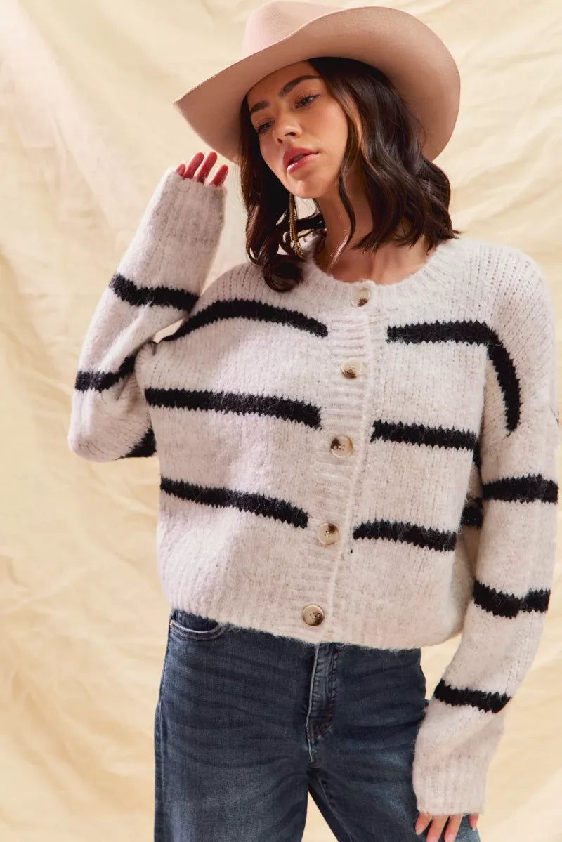 White striped button-down knit cardigan with long sleeves shown on a woman