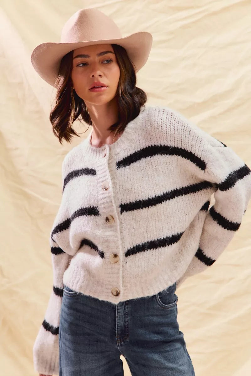 White striped button-down knit cardigan with long sleeves shown on a woman