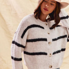 White striped button-down knit cardigan with long sleeves shown on a woman