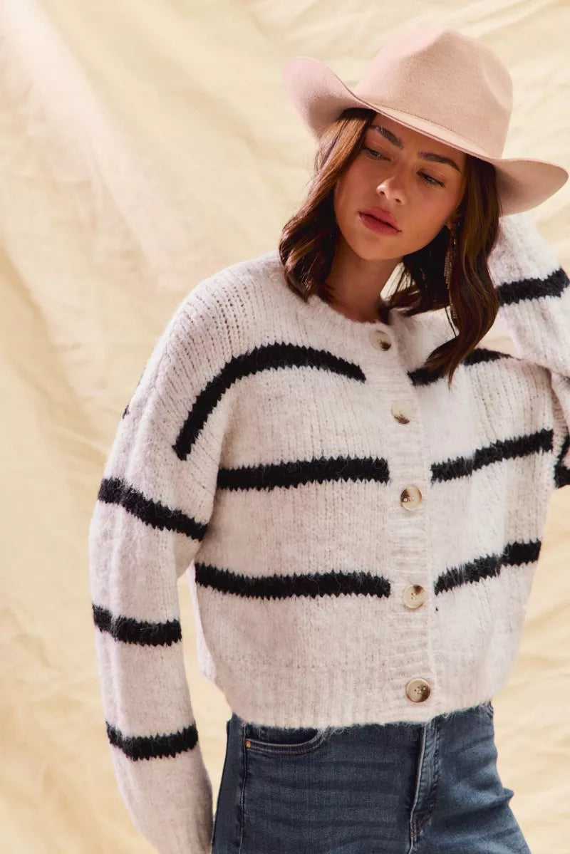 White striped button-down knit cardigan with long sleeves shown on a woman
