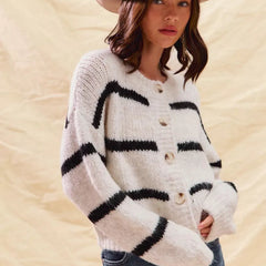 White striped button-down knit cardigan with long sleeves shown on a woman