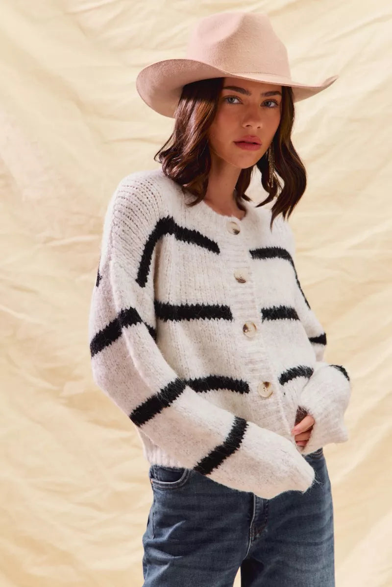 White striped button-down knit cardigan with long sleeves shown on a woman