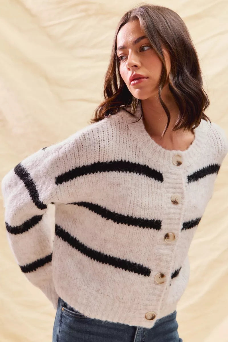 White striped button-down knit cardigan with long sleeves shown on a woman