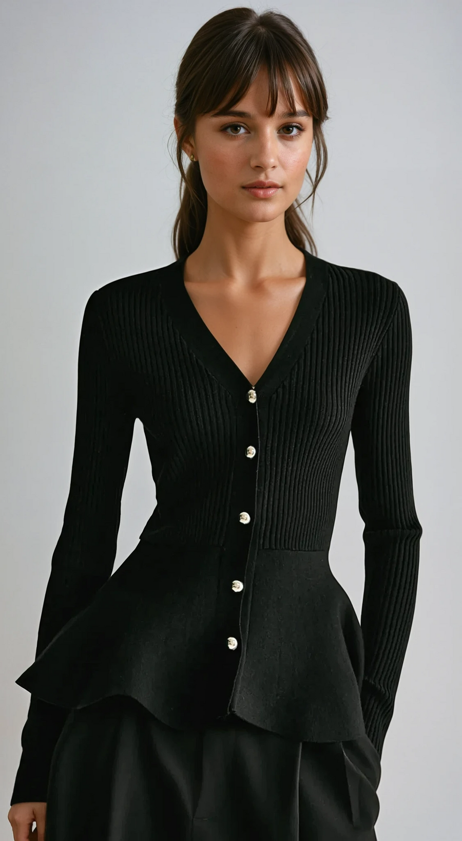 Black ribbed peplum knit top with metallic button detailing and fitted waist